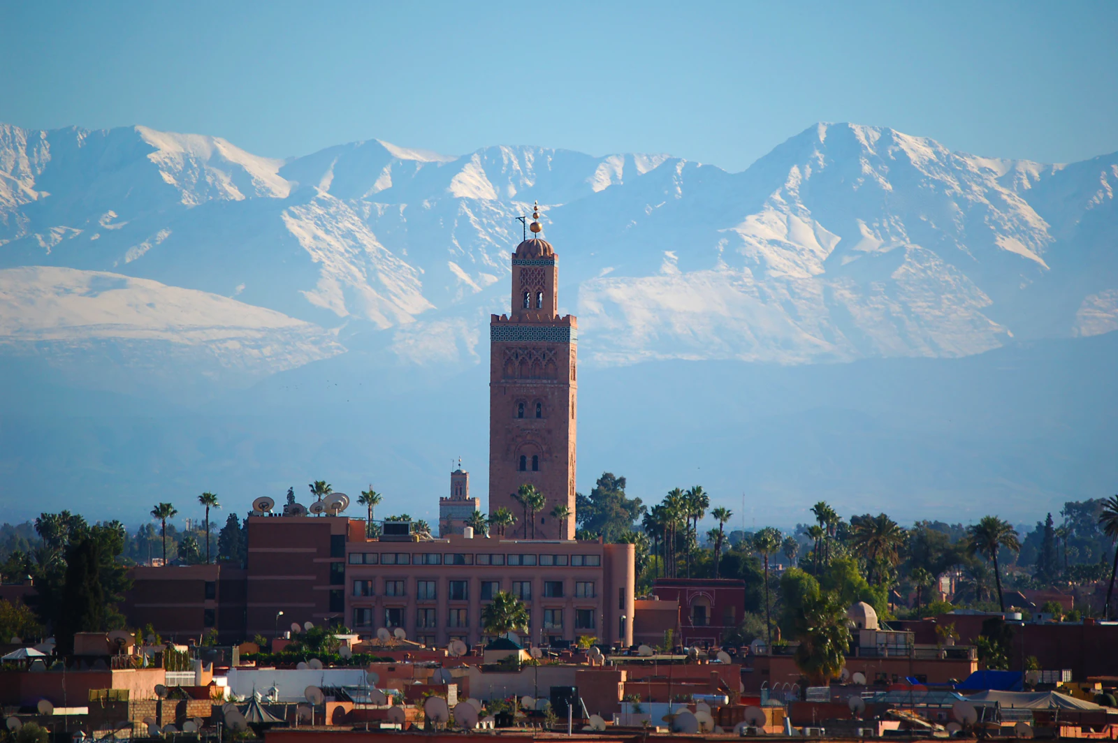 Koutoubia minaret above Marrakech with the snow-capped Atlas Mountains behind Koutoubia minaret above Marrakech with the snow-capped Atlas Mountains behind